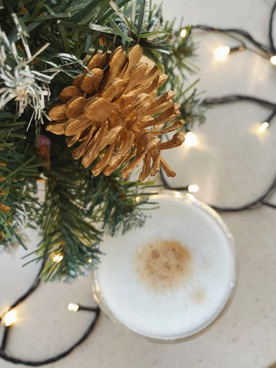 Centro de mesa navideño elegante con elementos de pino y vajilla de porcelana