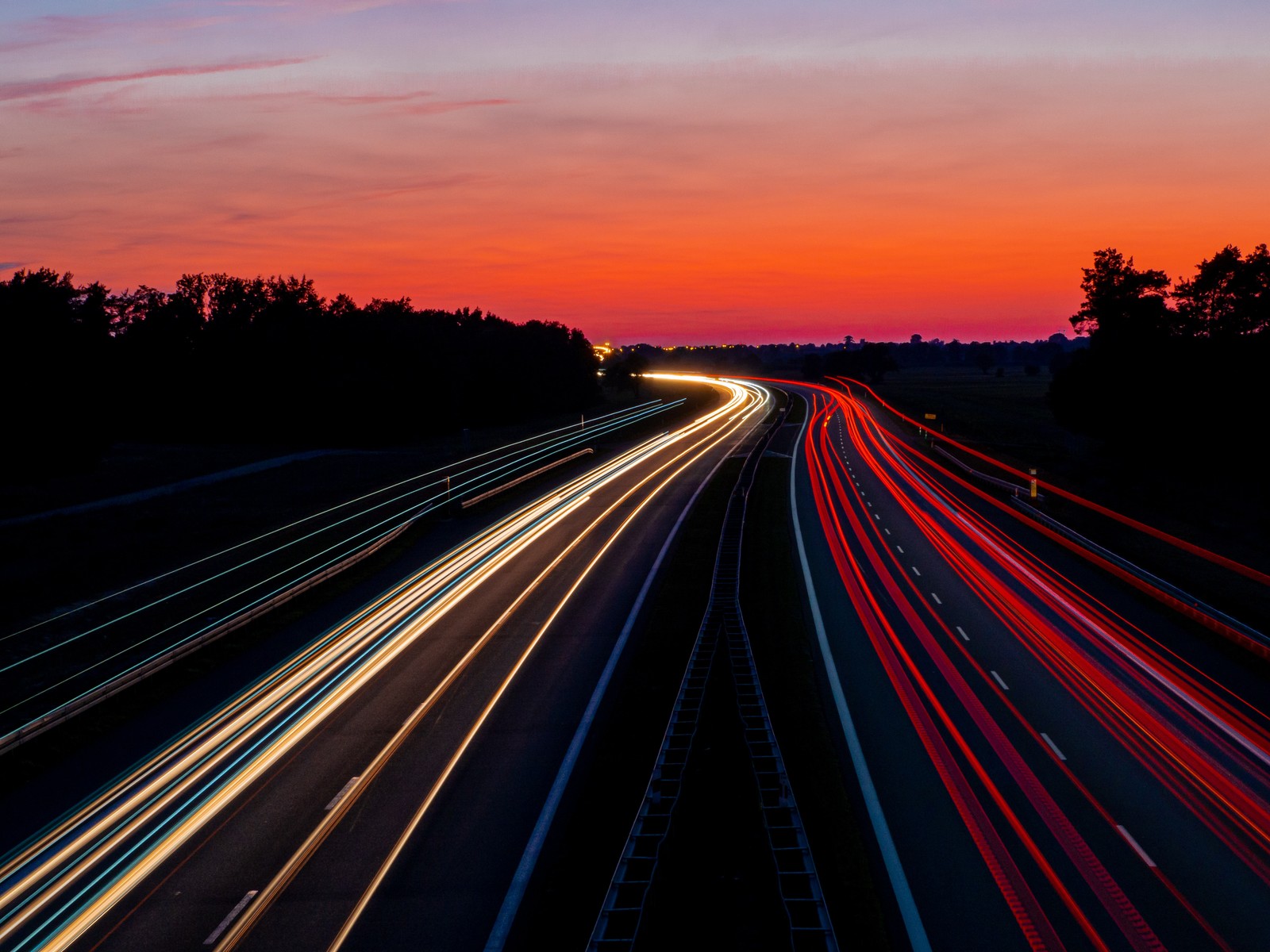 Arafed view of a highway with a long exposure of light trails (road, highway, red, horizon, light)