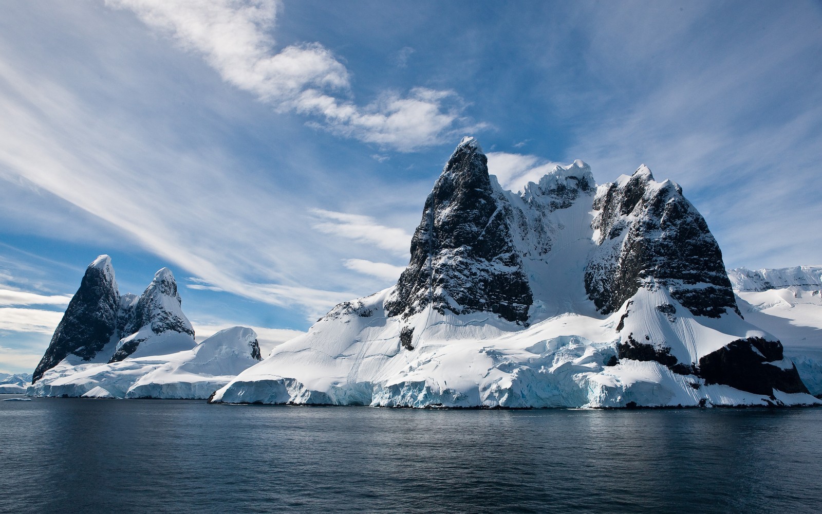 Montañas cubiertas de nieve y hielo en el océano (hielo, naturaleza, iceberg, montaña, océano ártico)