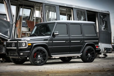 Elegante Mercedes-Benz G-Class estacionado ao lado de um trem abandonado, exibindo uma mistura de luxo e robustez em um ambiente urbano.