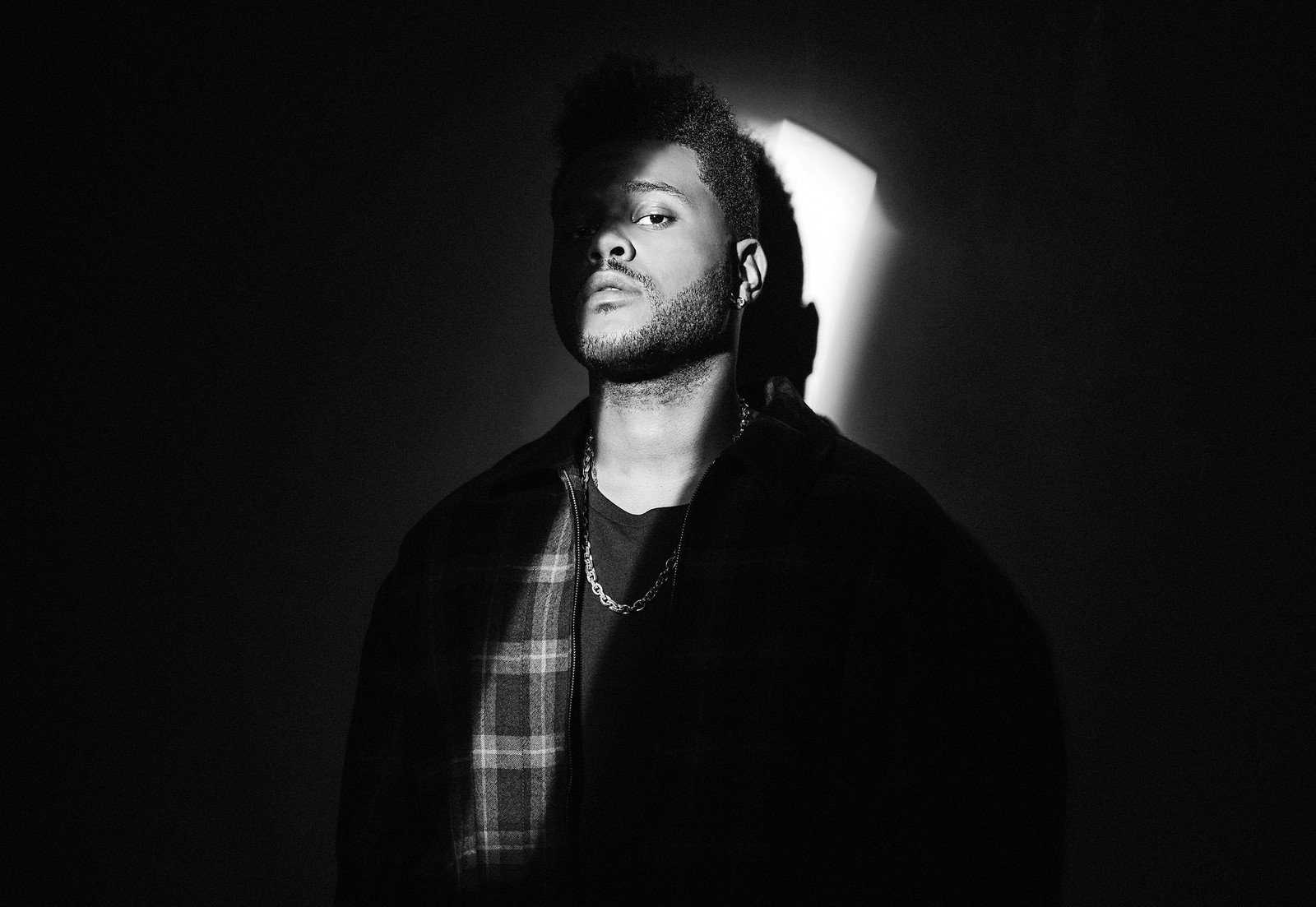 Arafed man with dreadlocks and a plaid shirt in a dark room (the weeknd, monochrome, canadian singer, abel makkonen tesfaye, black and white)