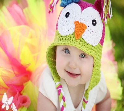 Adorable Baby in Colorful Owl Hat with Radiant Smile