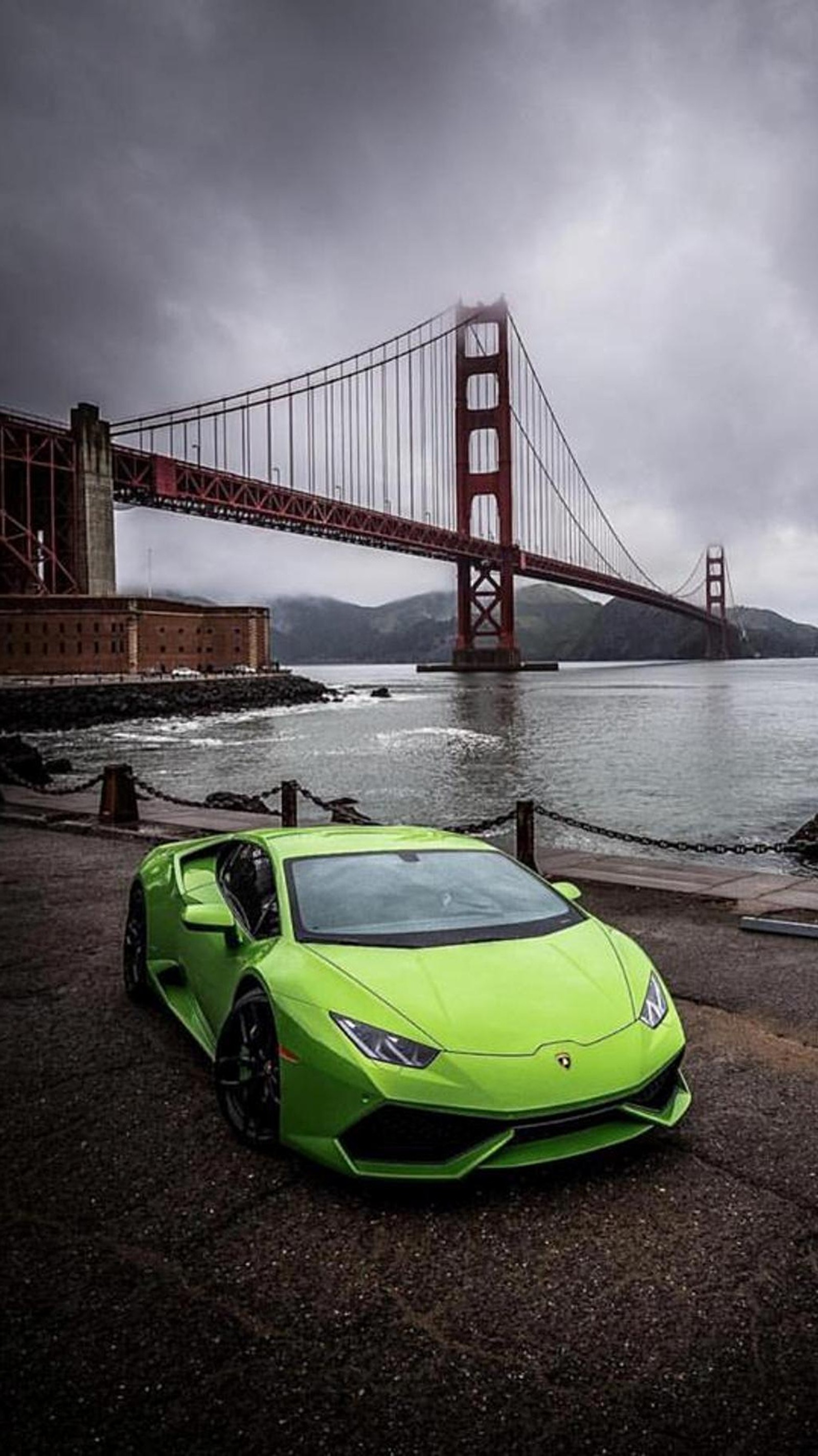 A close up of a green sports car parked near a bridge (car, green, lamborghini aventador)