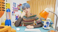 Soobin from Tomorrow X Together in a colorful, retro-inspired room, showcasing a playful yet contemplative mood.