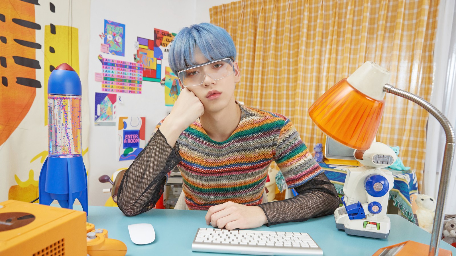 Uma mulher árabe com cabelo azul sentada a uma mesa com um teclado (txt kpop, tomorrow x together, 투모로우바이투게더, kpop, k pop)