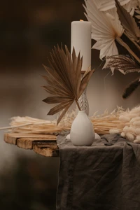 Nature morte élégante avec bougie, feuilles sèches et bois rustique