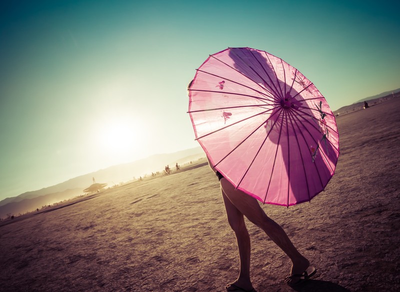 Арабская женщина с розовым зонтом идет по пляжу (pink umbrella, девочка, восход солнца, тень, ясное небо)