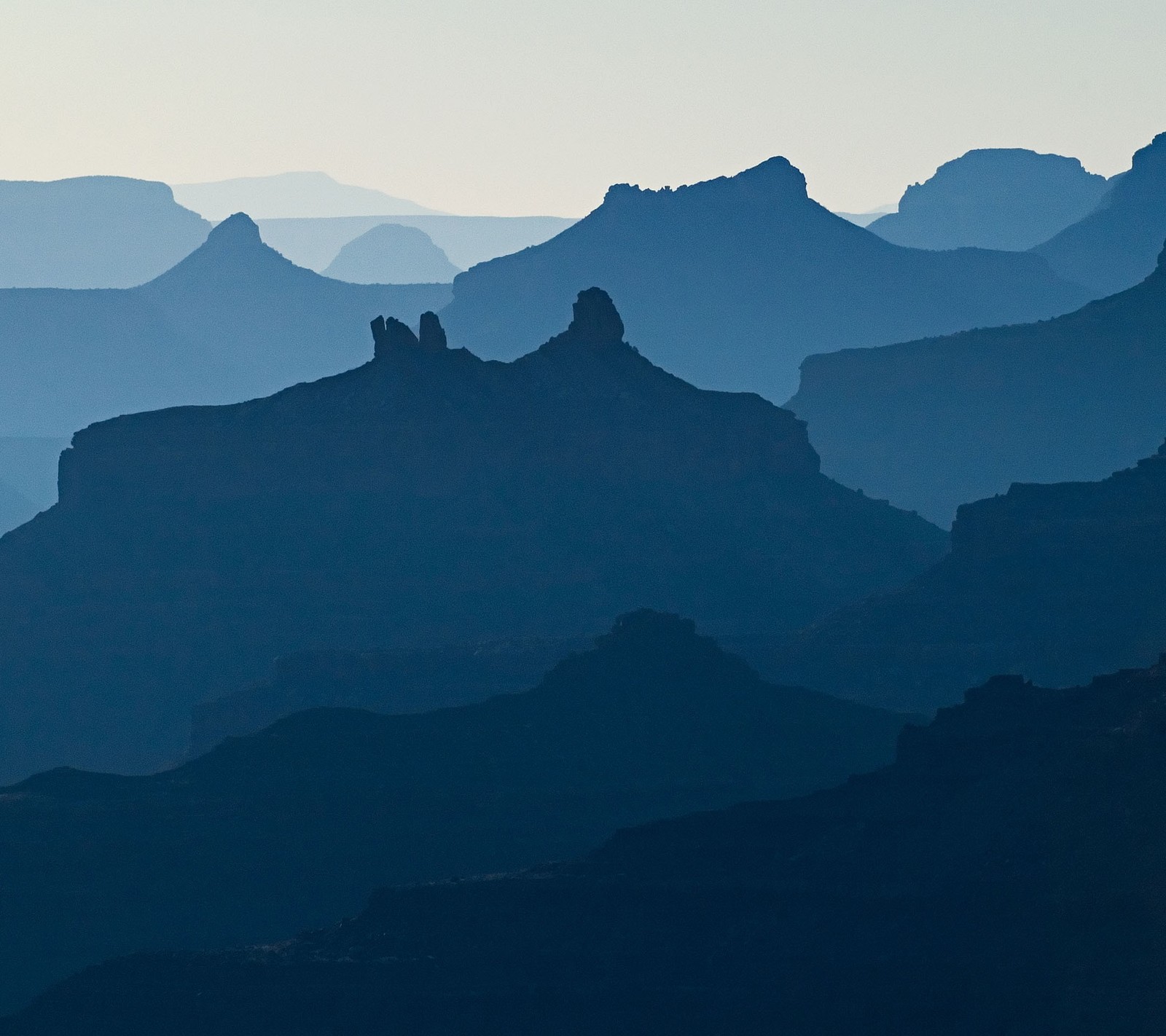 Mountains are silhouetted against a hazy sky in the distance (torres del paine national park, fitz roy, grand canyon, grand canyon village, mountain)