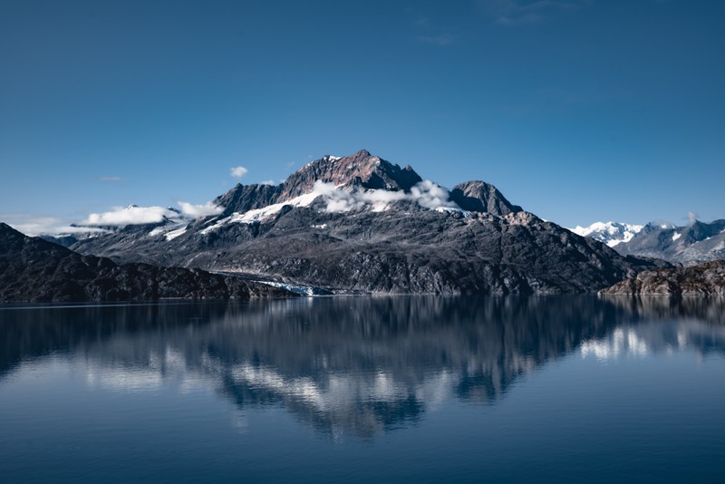 Вид сверху на горный хребет, отражающийся в озере с лодкой на воде (mount copper, lamplugh glacier, glacier bay national park, аляска, alaska)