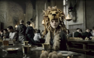 Une jeune fille en costume de lion est assise à une longue table de dîner, entourée d'étudiants dans un cadre de Poudlard.