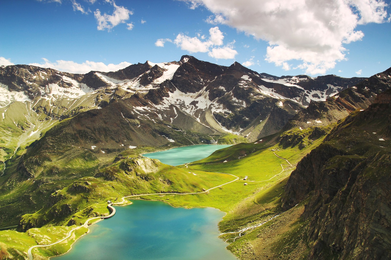 Eine aussicht auf einen see inmitten eines gebirges (ceresole reale, sommer, berge, see, sonniger tag)