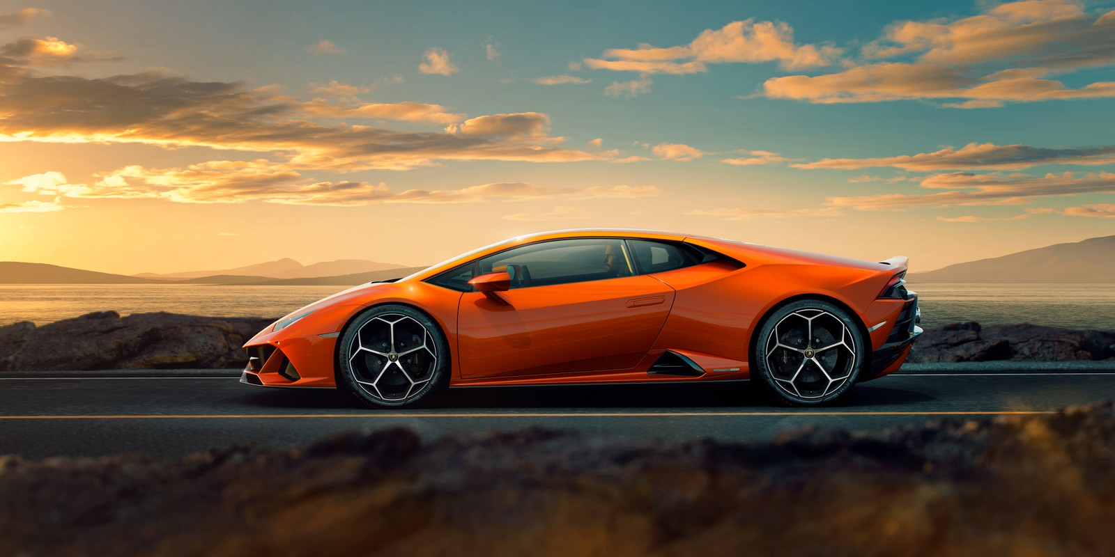 Ein orangefarbener lamborghini-sportwagen fährt bei sonnenuntergang eine straße entlang (lamborghini, auto, superauto, sportwagen, orange)