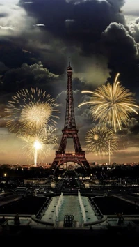 Fuegos artificiales iluminando la Torre Eiffel contra un cielo dramático