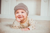 Adorable niño pequeño sonriente con gorro de punto acogedor