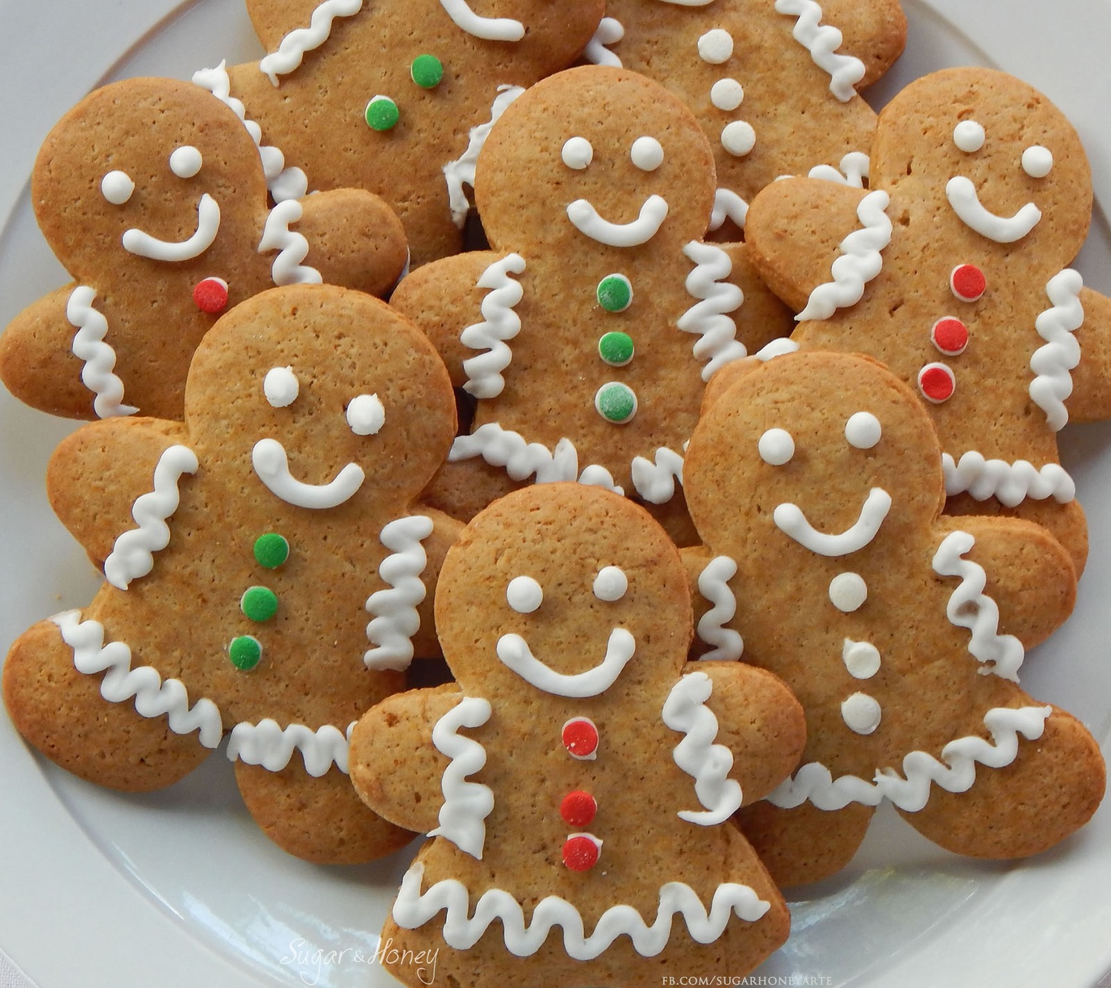 Un primer plano de un plato de galletas con glaseado y decoraciones (navidad, galletas, jengibre, pan de jengibre)