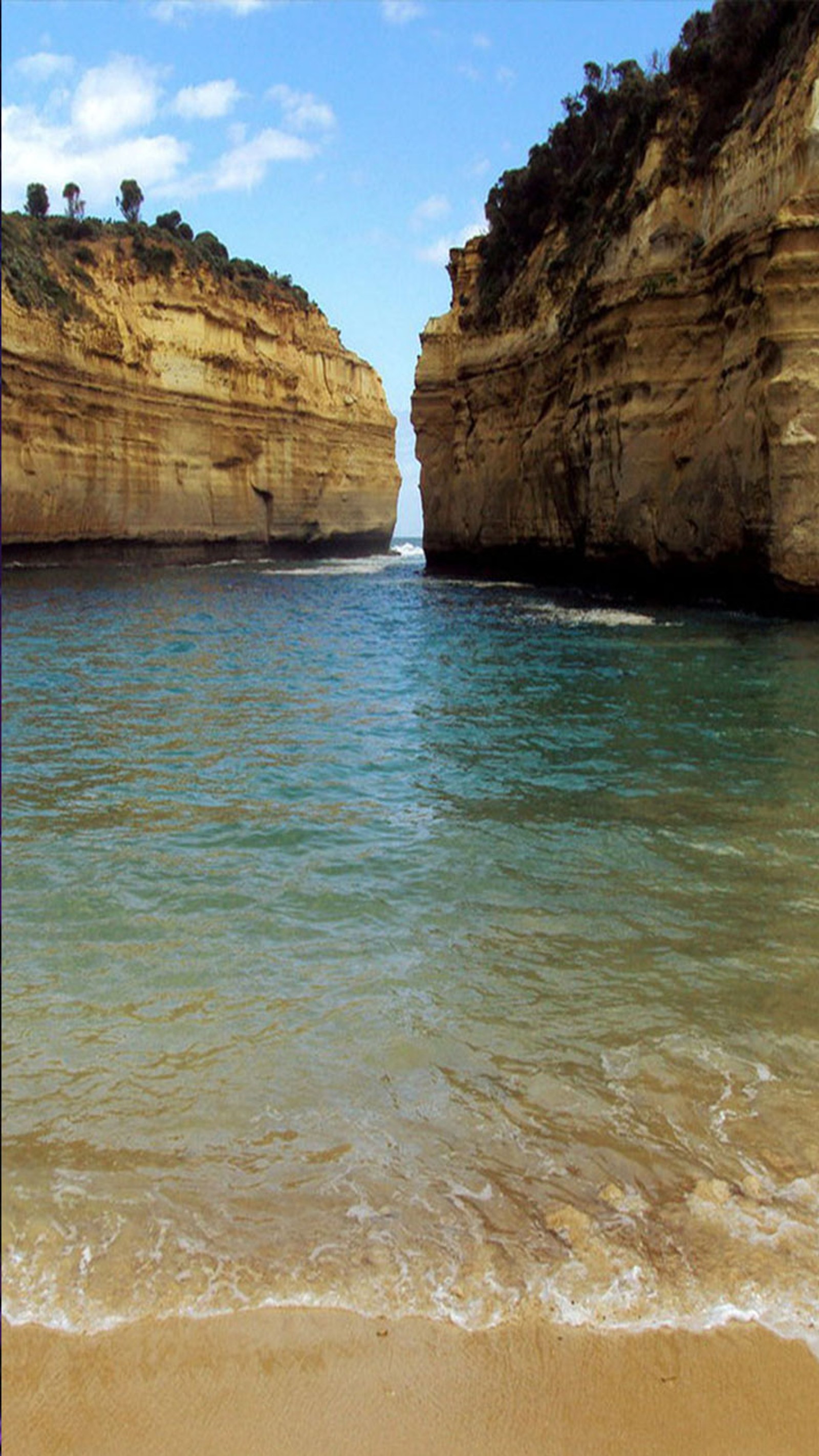 Il y a un grand plan d'eau avec une grande formation rocheuse à l'arrière-plan (mer, rivage)