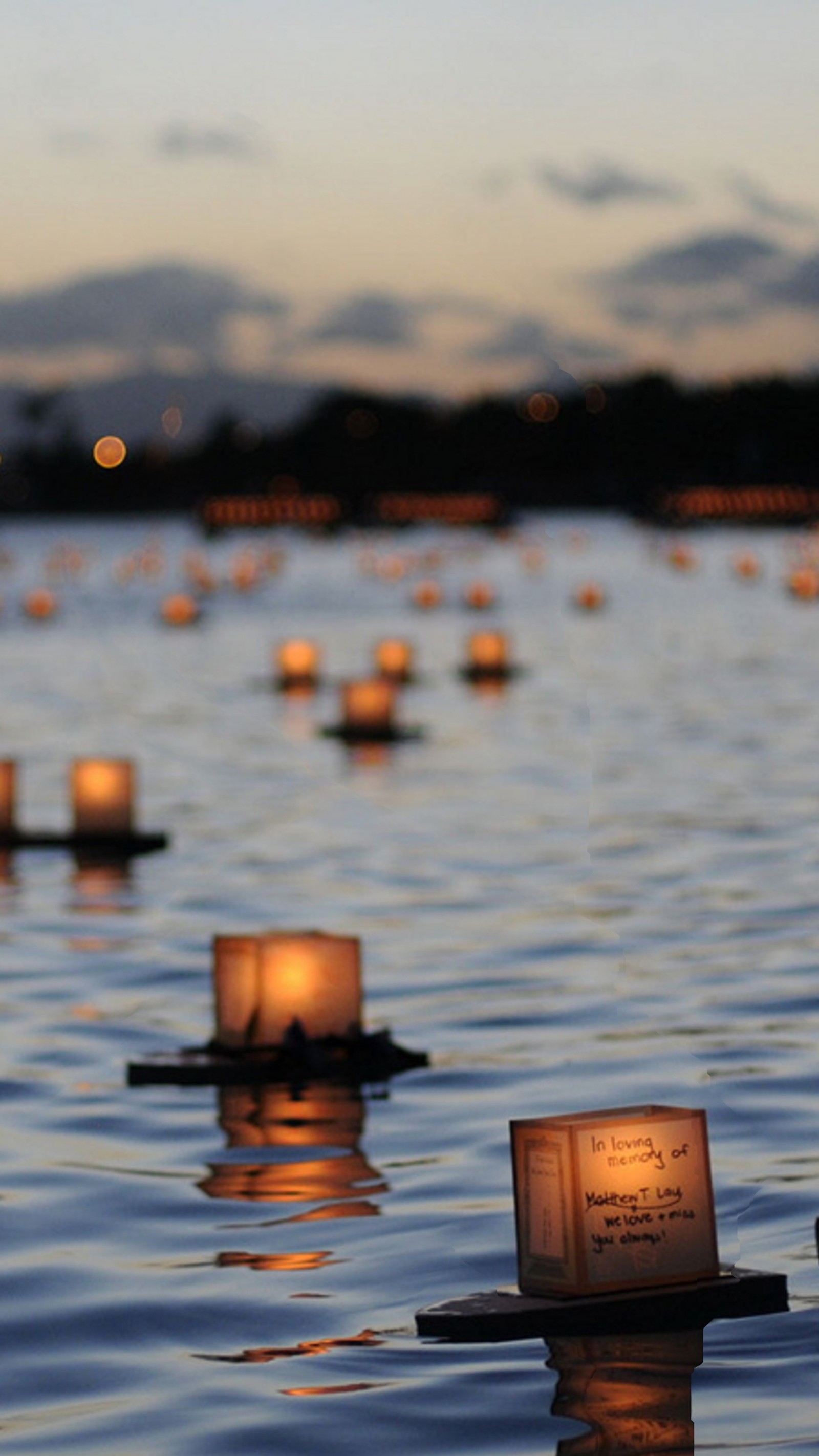 Velas flotando en el agua con un fondo de cielo (river candle, espiritual)