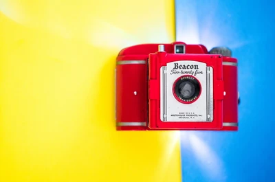 Appareil photo vintage rouge Beacon sur un fond jaune vif et bleu