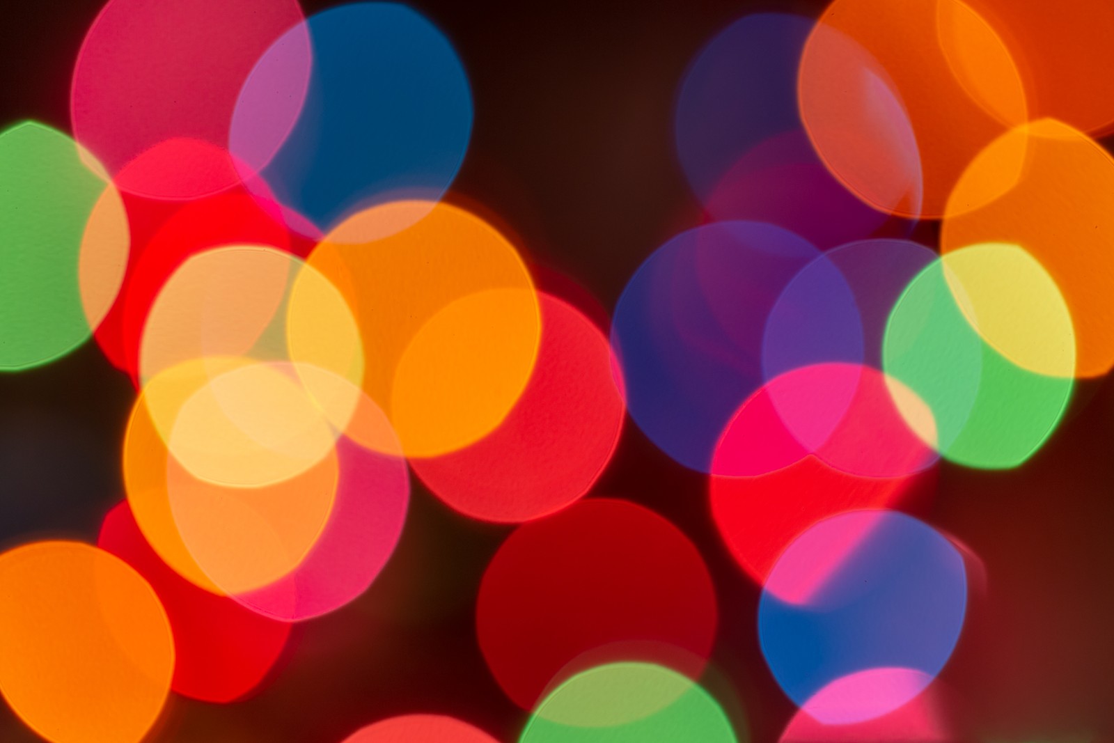 Bunt beleuchtete lichter sind auf einem schwarzen hintergrund in einem kreis angeordnet (lichter bokeh, unscharfer hintergrund, bunt, mehrfarbig, kreise)