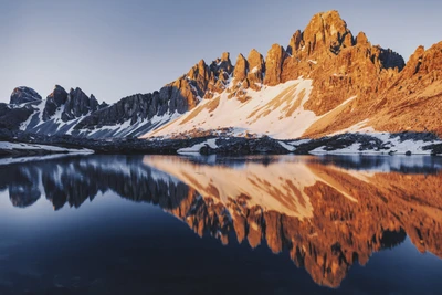 Reflejos del amanecer de las Tres Cumbres de Lavaredo en el Lago di Piano, Italia