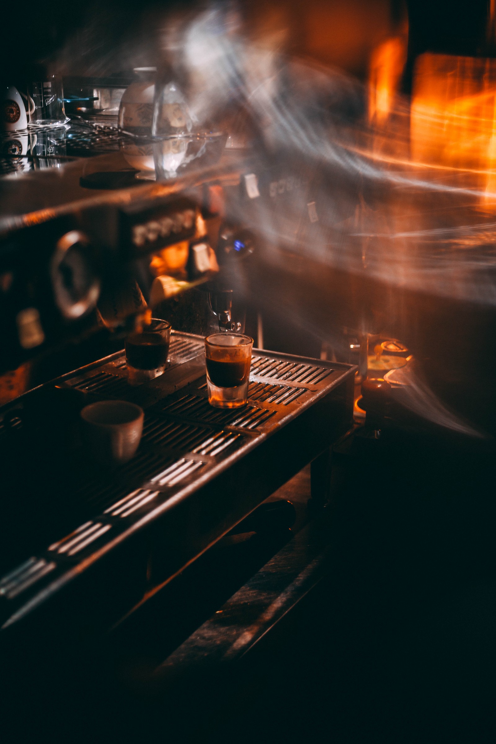 Machine à café préparant une boisson dans l'obscurité (café, fumée, chaleur, électronique, nuit)