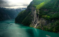 Stunning Geirangerfjord with Cascading Waterfall and Lush Highland Cliffs