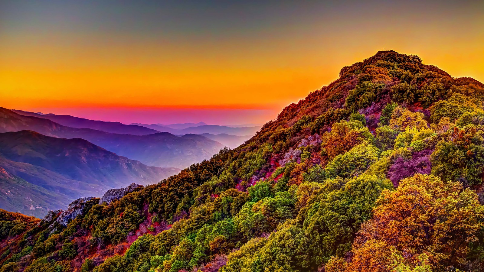 A mountain with a colorful sunset in the background (mountains, colorful, forest, nature, sunset)