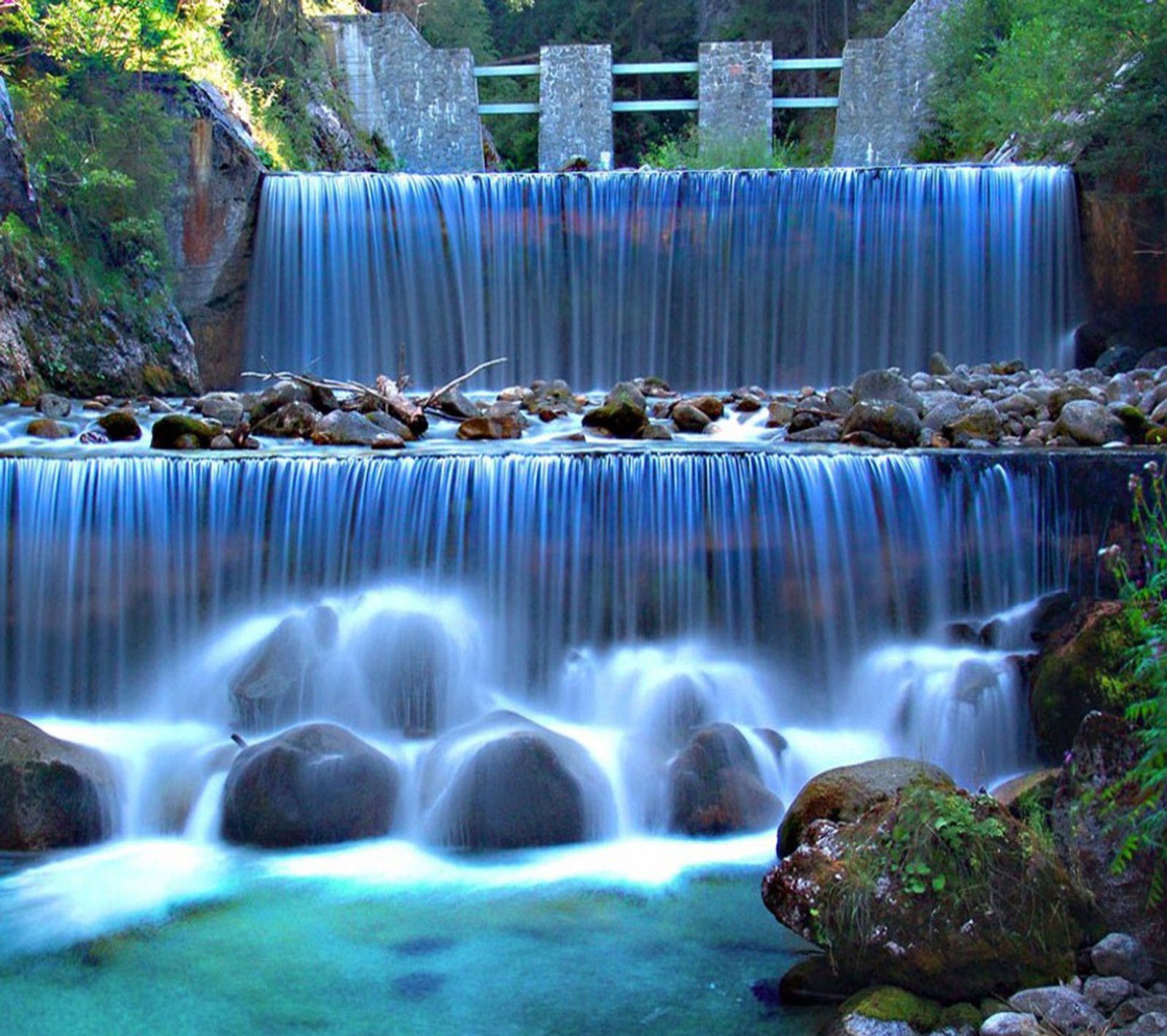 Un primer plano de una cascada com pedras e água (hd, magnifito, cascada)