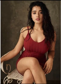 Ketika Sharma dans une tenue rouge frappante, dégageant confiance et élégance tout en étant assise gracieusement.