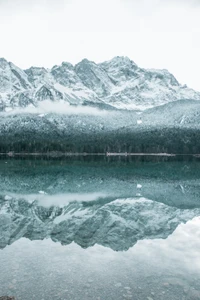 Serene Gletscherlandschaft: Schneebedeckte Berge spiegeln sich in einem ruhigen See