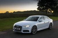 2017 Audi A4 Sedan with Alloy Wheels Against a Scenic Sunset Background