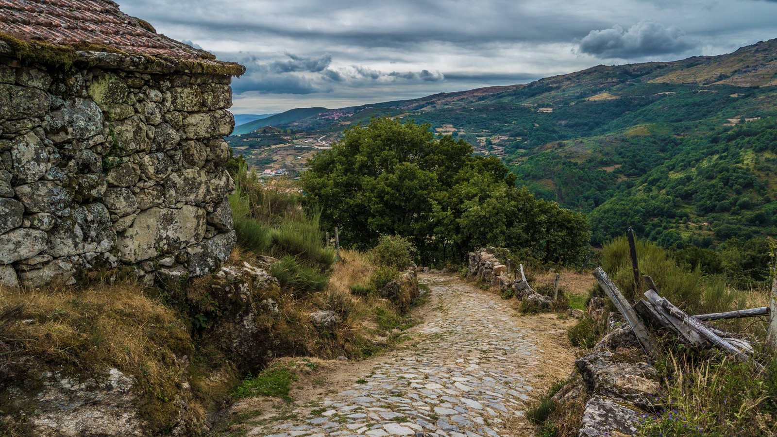 Um caminho de pedra levando a um edifício de pedra em uma colina (wild, formas montanhosas, paisagem natural, montanha, terras altas)