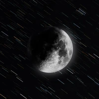 Luna monocromática con estelas de estrellas contra un fondo oscuro