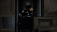 A lone figure in shadowy attire stands in a narrow corridor, exuding a sense of mystery and intrigue, evoking the essence of a gripping ninja drama.