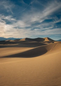 Dunes dorées sous un ciel bleu : Beauté éolienne de la Vallée de la Mort