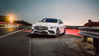 Элегантный Mercedes-Benz AMG припаркован на живописной дороге на закате.