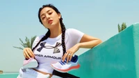 Jihyo from TWICE showcases Under Armour footwear in a vibrant outdoor photoshoot.