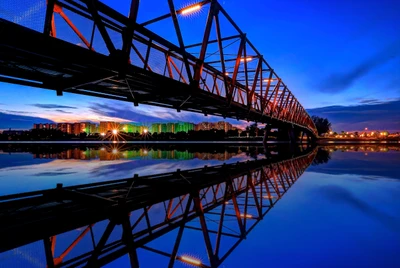 Reflejos crepusculares de un puente de la ciudad sobre aguas tranquilas