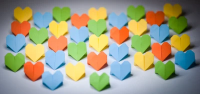 Corazones de origami coloridos en un patrón vibrante