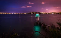 Beleuchteter Leuchtturm im Hafen von Sydney während der Dämmerung