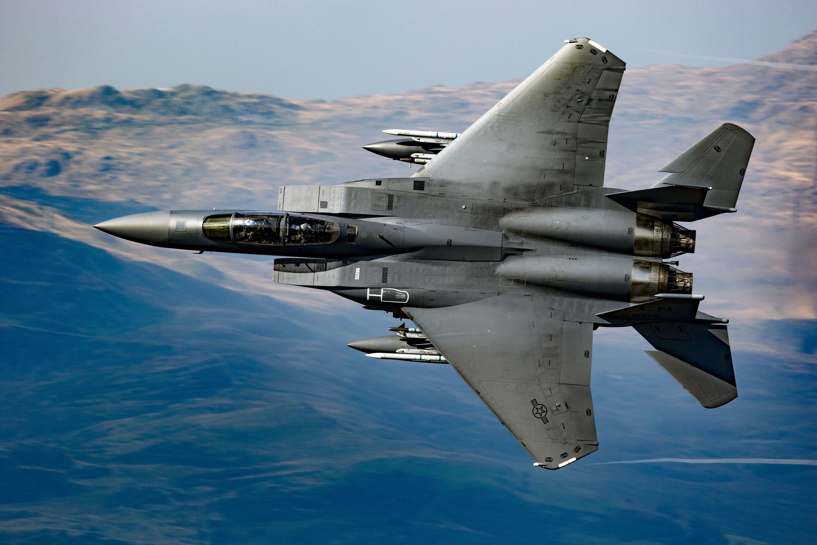 Un chasseur arabe volant dans le ciel avec des montagnes en arrière-plan (mcdonnell douglas f 15 eagle, boeing fa 18ef super hornet, boeing f a 18e f super hornet, mcdonnell douglas, aéronef)