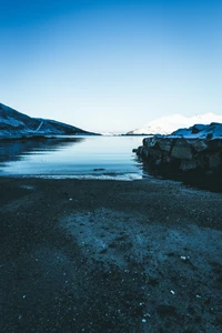 Sereno lago glacial rodeado de montañas y fiordos