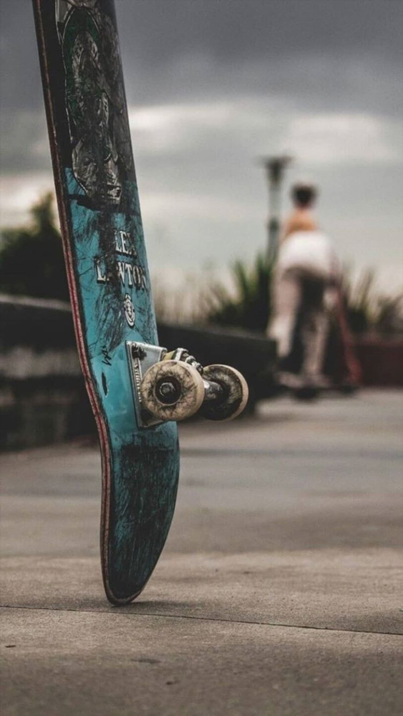 There is a skateboard that is sitting on the ground (outside, skate)