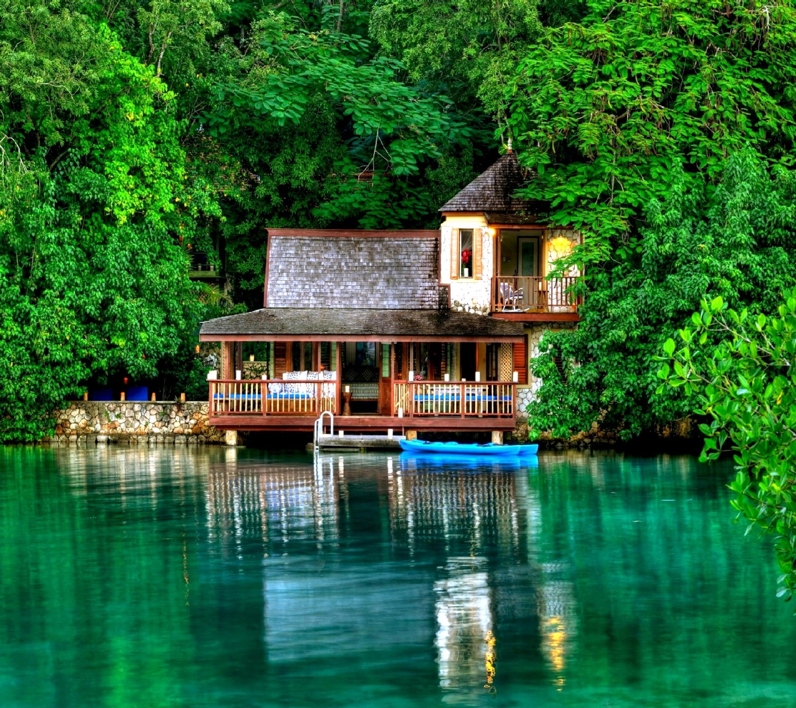 There is a boat that is sitting in the water near a house (nature)