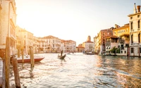 Sunset over Venice's scenic canal, with gondolas gliding through the shimmering water amid stunning architecture.