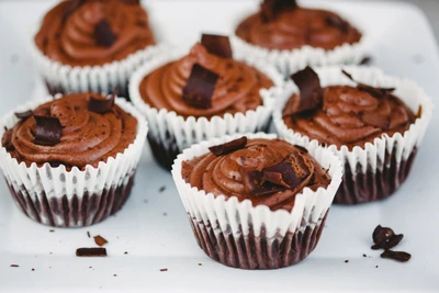 Cupcakes de chocolate decadentes cubiertos con rica crema de mantequilla y virutas de chocolate negro.