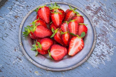 Freshly sliced strawberries arranged on a rustic plate.