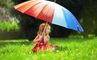 Charming Girl with a Colorful Umbrella in a Sunny Meadow