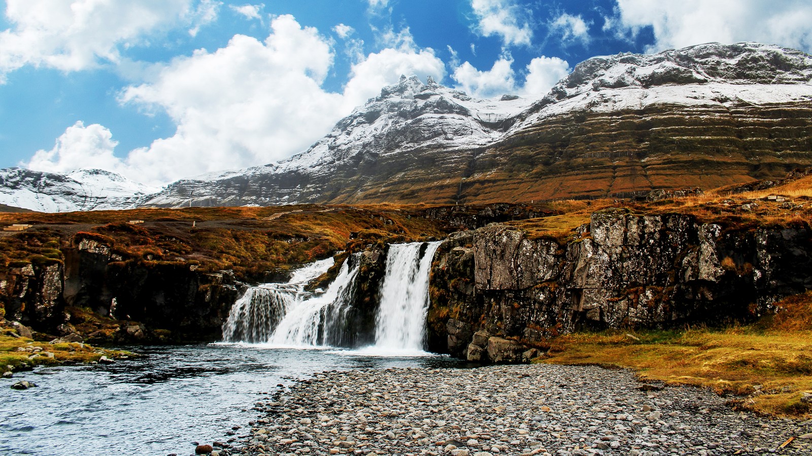 Um close de uma cachoeira em uma área rochosa com uma montanha ao fundo (cachoeira, montanha, rochas, wild, paisagem)