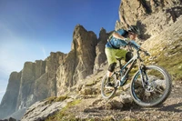 Mountainbiker, der unwegsames Gelände vor einer dramatischen Bergkulisse navigiert